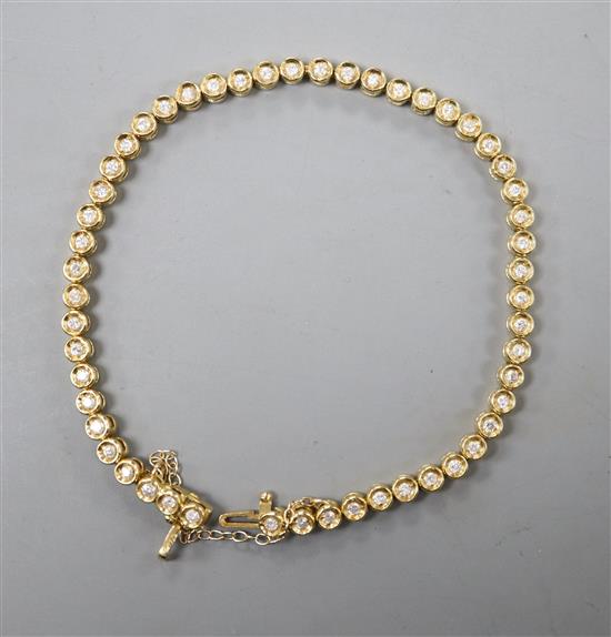 An 18ct gold and diamond set line bracelet, with safety chain, approx. 18cm, gross 12.8 grams.